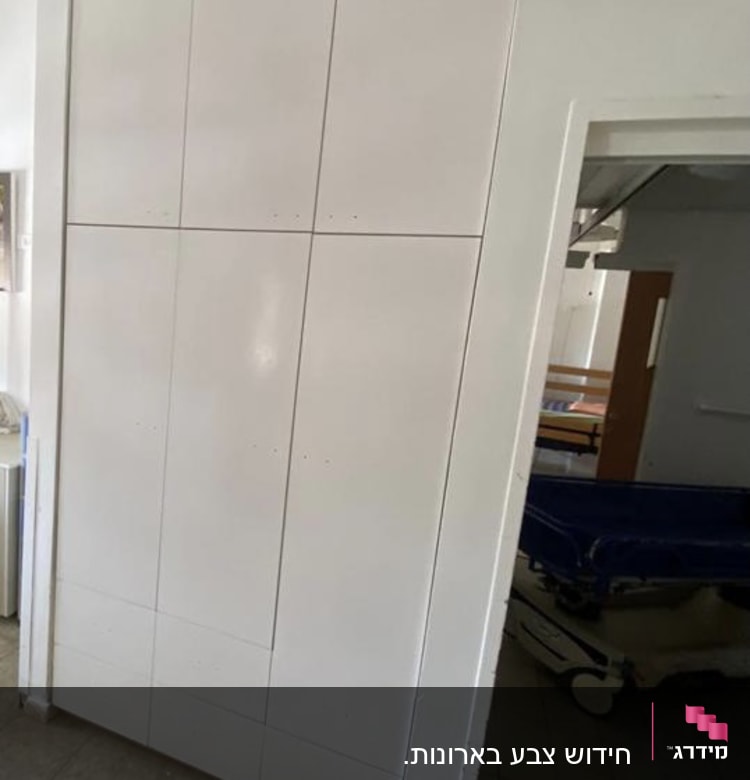 קיר צבוע בלבן עם דלת פתוחה חלקית